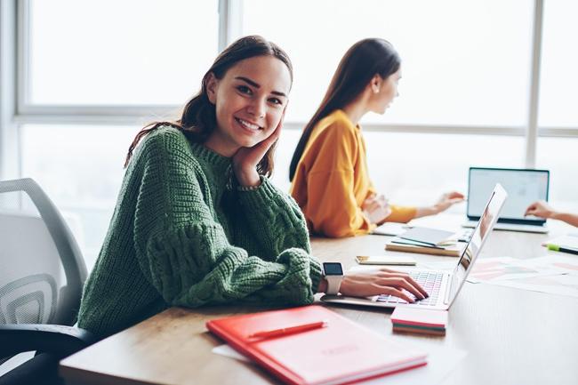 A student posing towards the camera while filling her college application 